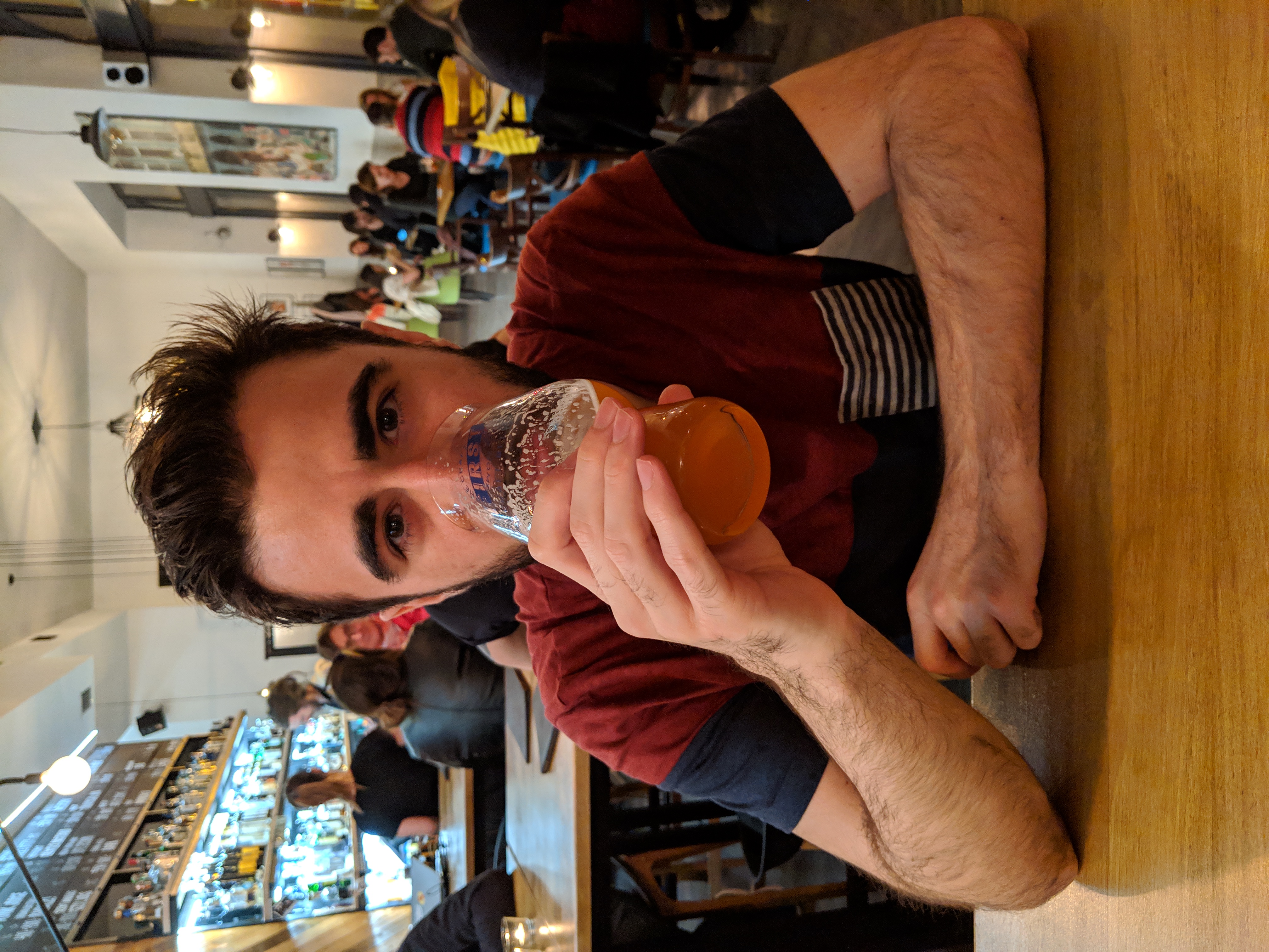 Portrait au comptoir d'un bar à bières, verre d'IPA à la bouche